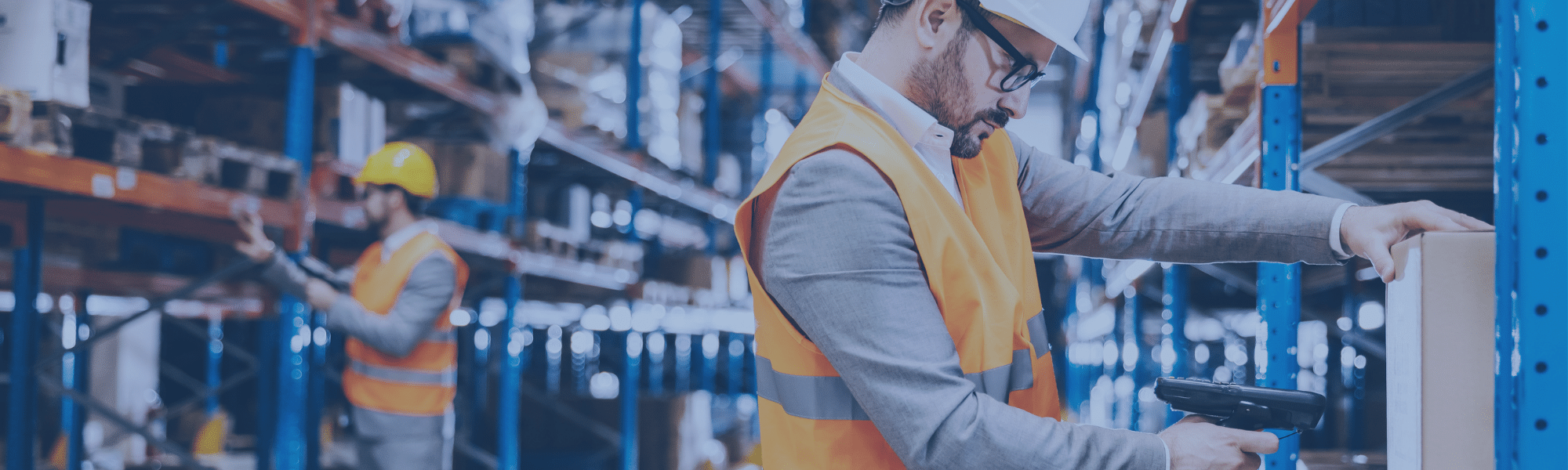 Two men in a warehouse scanning boxes