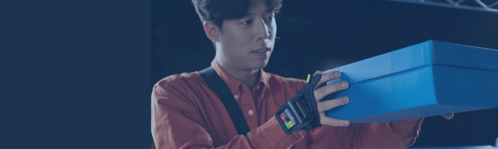 Male warehouse worker wearing a hand device for warehouse